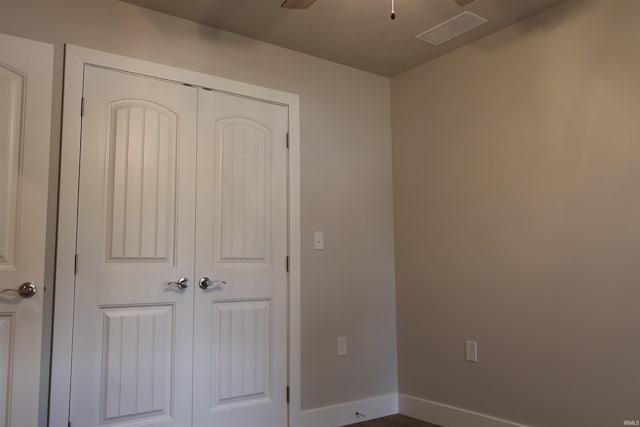 unfurnished bedroom with ceiling fan and a closet