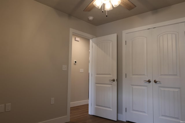 unfurnished bedroom with a closet, ceiling fan, and dark hardwood / wood-style floors