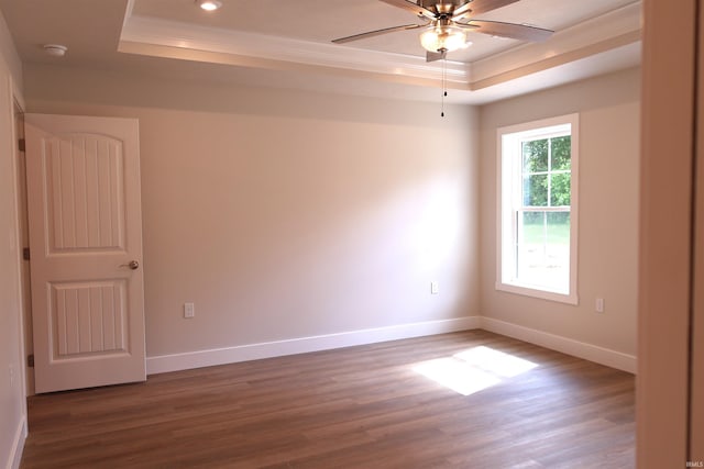 spare room featuring a tray ceiling, crown molding, hardwood / wood-style flooring, and ceiling fan