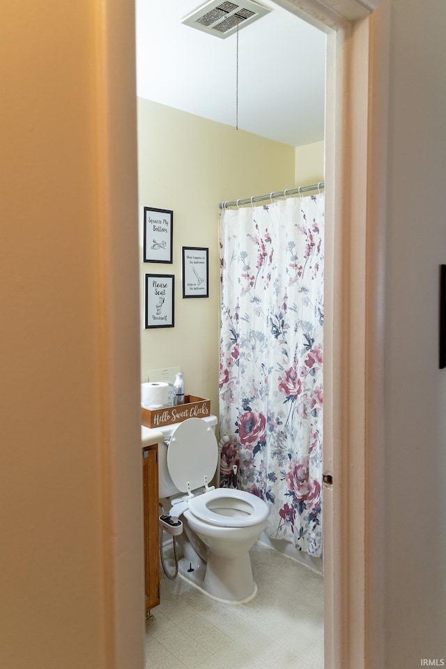 bathroom featuring tile floors and toilet