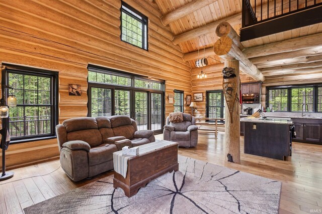 living room with high vaulted ceiling, light hardwood / wood-style floors, and rustic walls