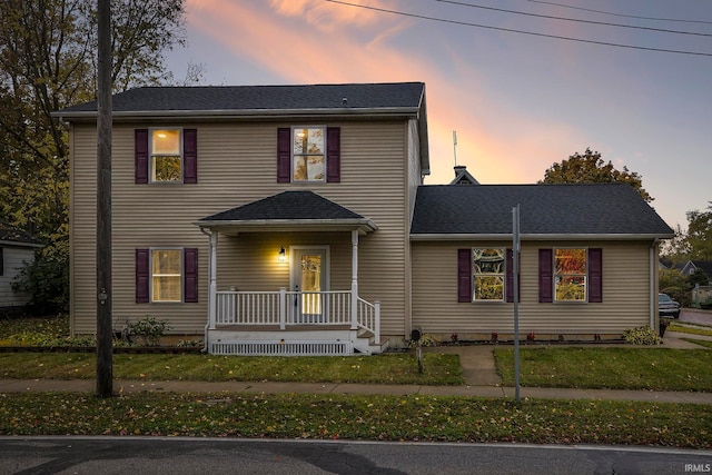 view of front of house with covered porch and a lawn