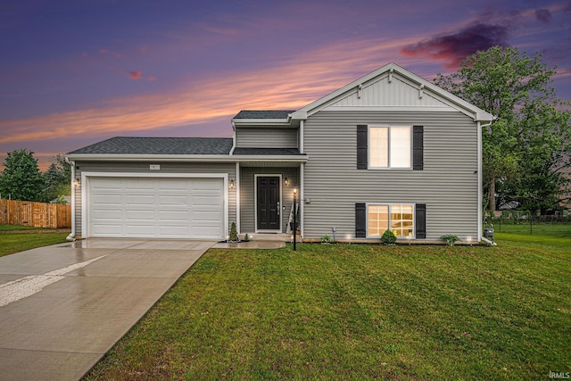 split level home featuring a garage and a lawn