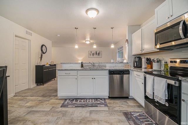 kitchen featuring stainless steel appliances, sink, white cabinets, and kitchen peninsula