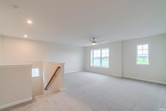 carpeted spare room featuring ceiling fan