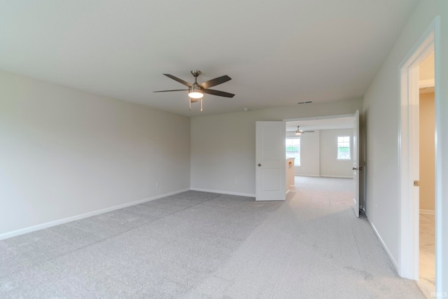 carpeted spare room featuring ceiling fan