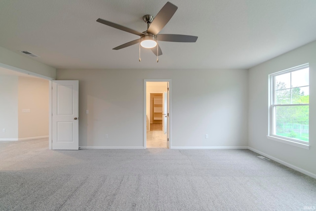 carpeted spare room with ceiling fan