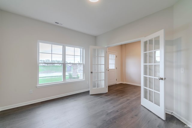 spare room with french doors and dark hardwood / wood-style floors