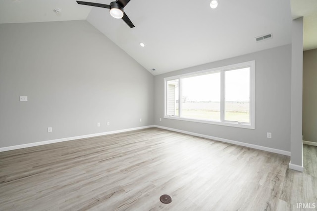 spare room with light wood-type flooring, vaulted ceiling, and ceiling fan