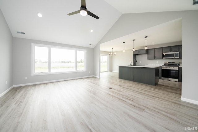 kitchen featuring ceiling fan, an island with sink, hanging light fixtures, light hardwood / wood-style flooring, and stainless steel appliances