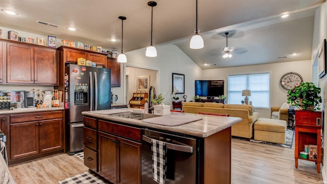 kitchen featuring stainless steel fridge, light wood-type flooring, a center island with sink, decorative light fixtures, and ceiling fan