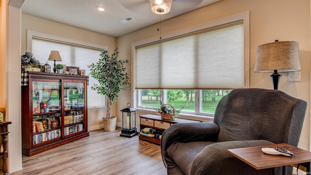 living area featuring light hardwood / wood-style floors and ceiling fan