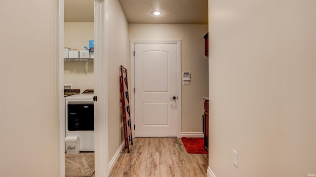 doorway with light hardwood / wood-style flooring and washing machine and clothes dryer