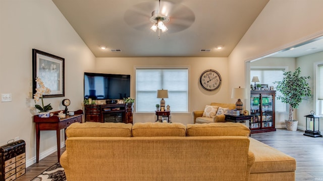 living room with plenty of natural light, lofted ceiling, wood-type flooring, and ceiling fan