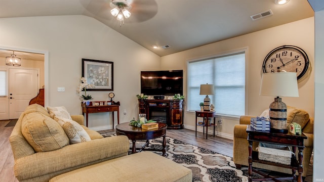 living room featuring ceiling fan, vaulted ceiling, a wealth of natural light, and wood-type flooring