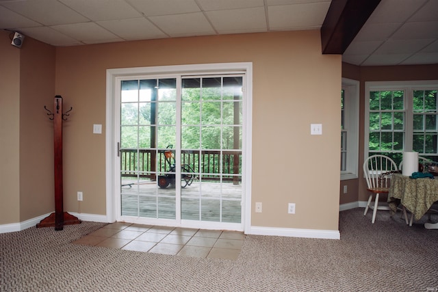 doorway with a healthy amount of sunlight, carpet flooring, and a drop ceiling