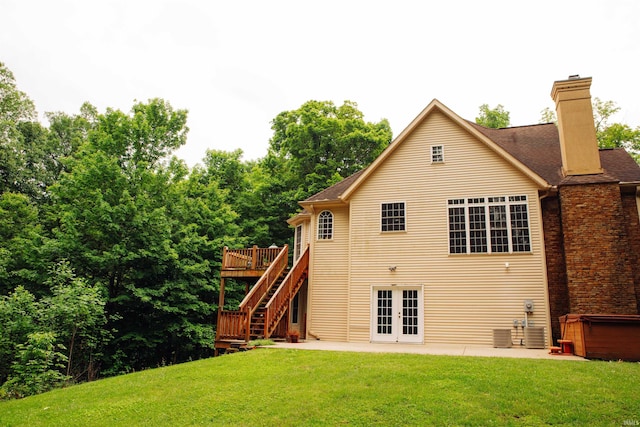 back of house with a patio, french doors, a hot tub, a deck, and a yard