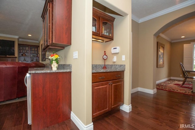 kitchen featuring dark hardwood / wood-style flooring, crown molding, and light stone countertops