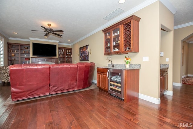 living room with dark hardwood / wood-style flooring, ornamental molding, ceiling fan, and beverage cooler