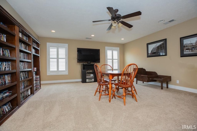 carpeted dining room featuring plenty of natural light and ceiling fan