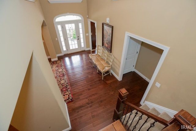 entryway with a high ceiling and wood-type flooring