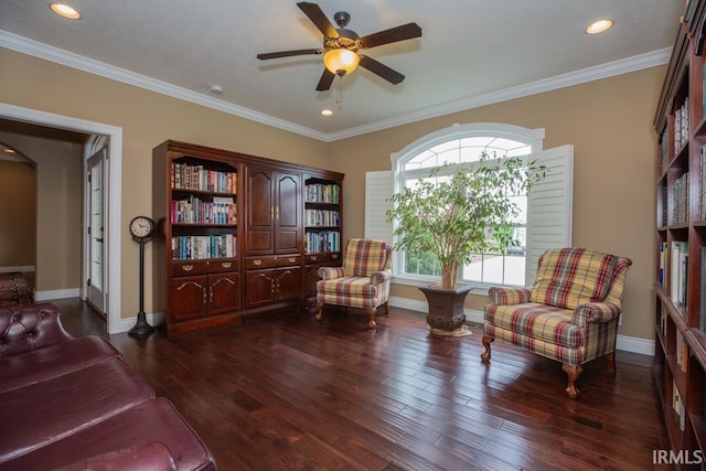 living area featuring ceiling fan, ornamental molding, and dark wood-type flooring