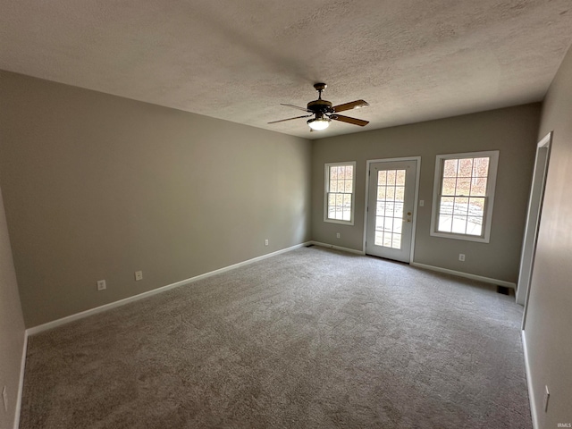 unfurnished room with a textured ceiling, carpet, and ceiling fan