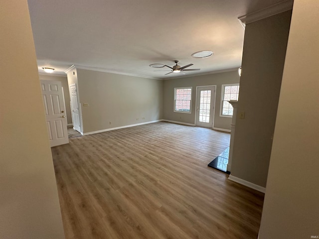 empty room featuring crown molding, wood-type flooring, and ceiling fan