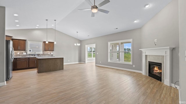 kitchen featuring light hardwood / wood-style flooring, a fireplace, tasteful backsplash, a center island, and pendant lighting