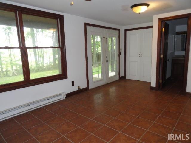 interior space featuring baseboard heating, french doors, and a healthy amount of sunlight