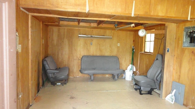 sitting room featuring wood walls and concrete floors