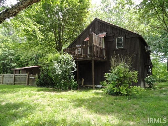 rear view of property with a lawn and a wooden deck