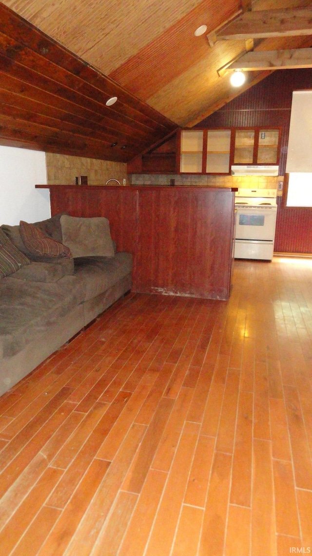 unfurnished living room featuring hardwood / wood-style floors, lofted ceiling, wooden walls, and wooden ceiling