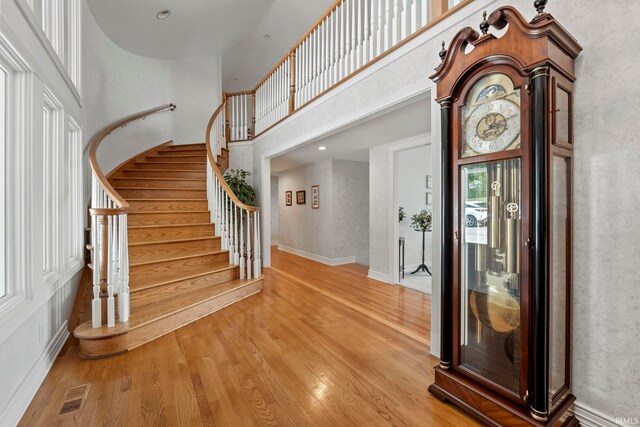 foyer with a towering ceiling and light wood-type flooring