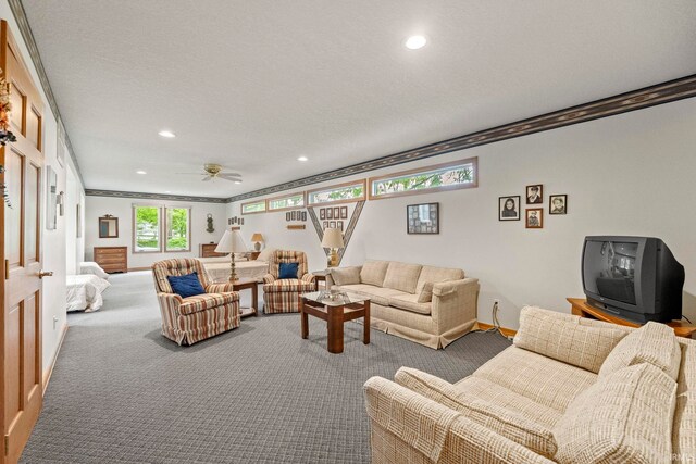 carpeted living room with a textured ceiling, ornamental molding, and ceiling fan