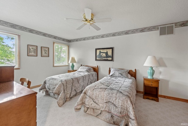 bedroom with carpet, ceiling fan, and a textured ceiling