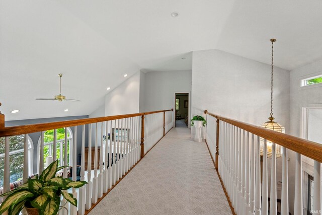 hallway featuring light carpet and high vaulted ceiling