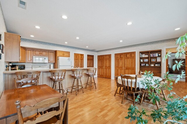 dining area featuring built in features and light hardwood / wood-style flooring