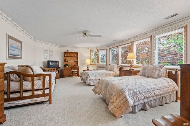 bedroom with ceiling fan, carpet floors, and crown molding