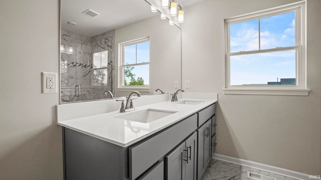 bathroom featuring tile floors, a tile shower, large vanity, and double sink