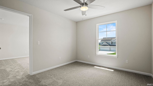 carpeted spare room featuring a wealth of natural light and ceiling fan