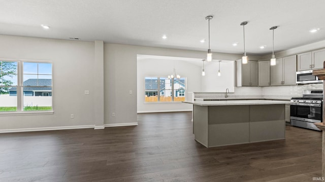 kitchen featuring dark hardwood / wood-style floors, stainless steel appliances, a healthy amount of sunlight, and pendant lighting