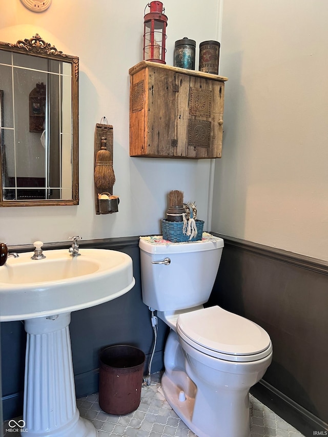 bathroom featuring tile flooring and toilet