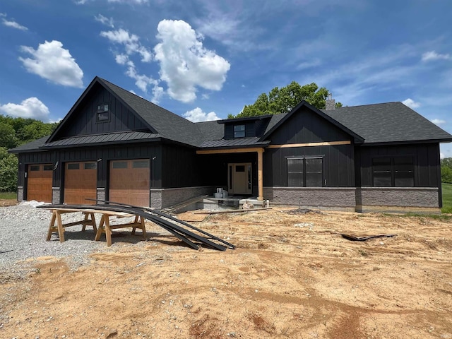 view of front facade with a standing seam roof, a garage, board and batten siding, and metal roof