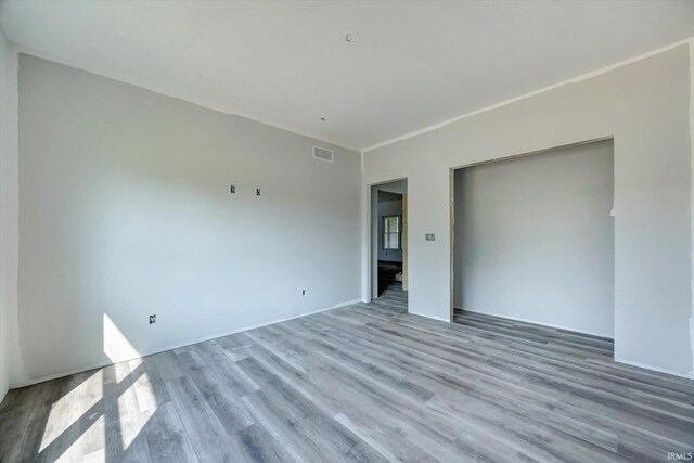 spare room featuring wood finished floors and visible vents