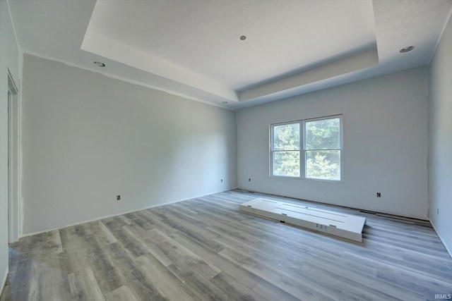 unfurnished room featuring a tray ceiling and wood finished floors