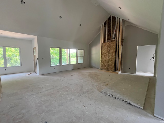 unfurnished living room featuring high vaulted ceiling