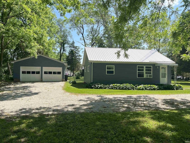 view of front of property with a front yard, an outdoor structure, and a garage