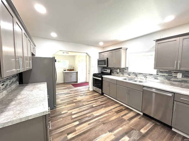 kitchen with stainless steel appliances, sink, dark hardwood / wood-style flooring, and backsplash