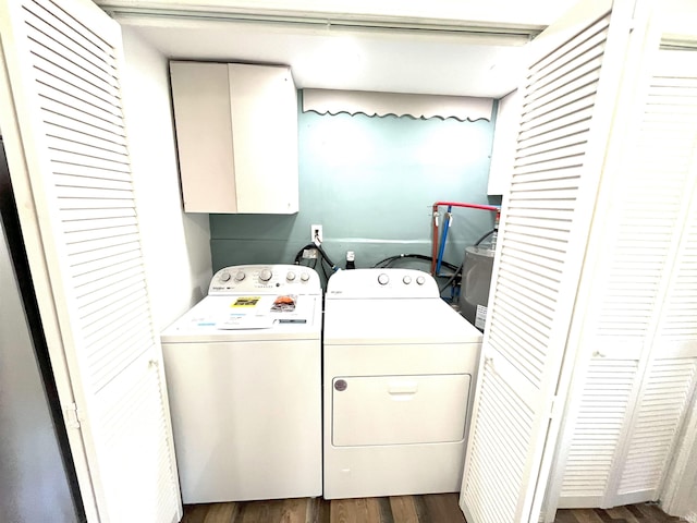 washroom featuring cabinets, washing machine and dryer, and wood-type flooring